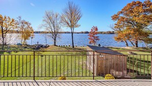 A lakeside property with a wooden shed, a fenced yard, and a clear view of the lake. - Lake + Ledge Retreat l Modern Luxury Home on Pike Lake (Hatley)