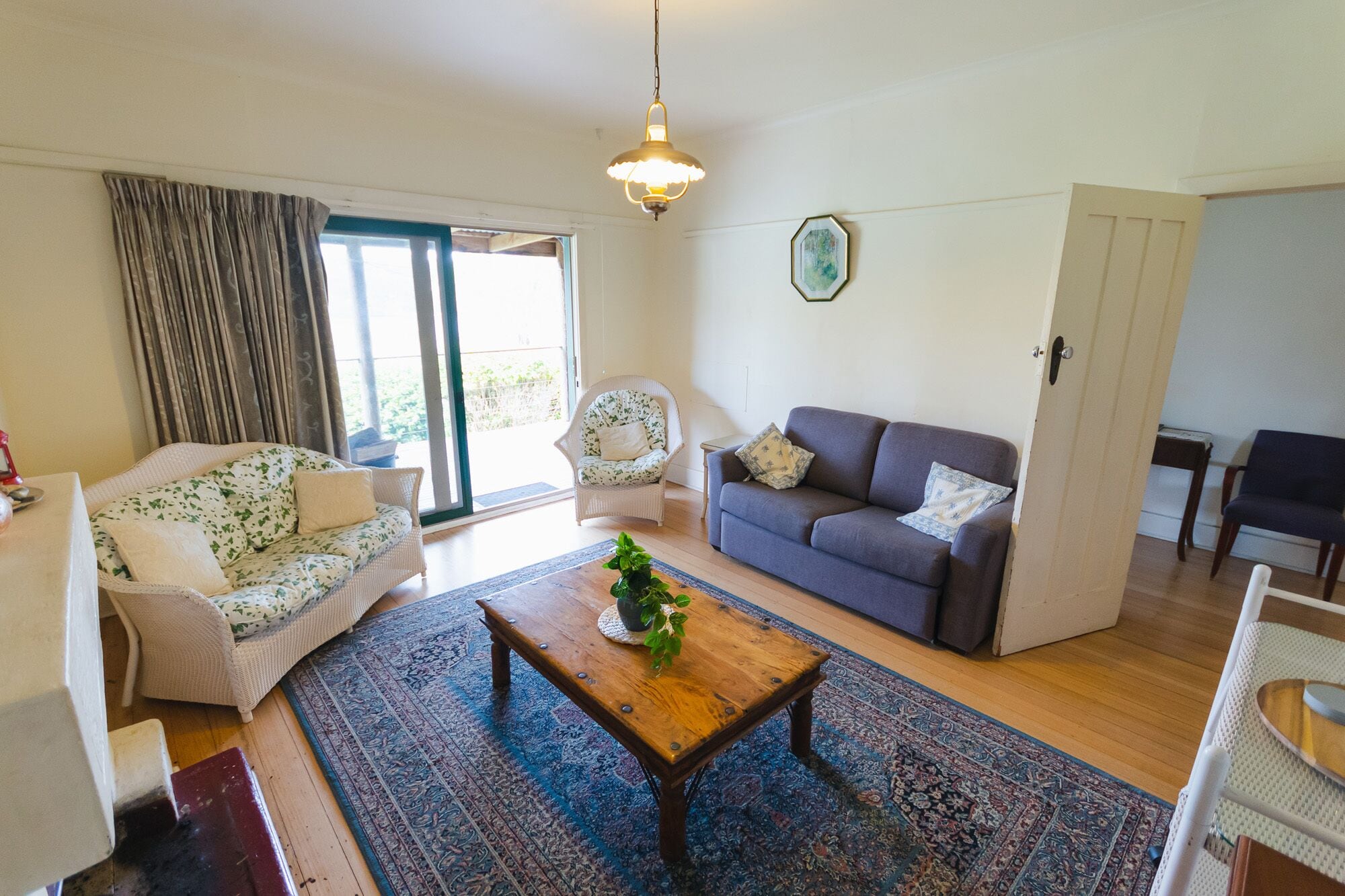 Een woonkamer met een bank, twee fauteuils, een salontafel en een vloerkleed.
