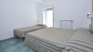 A small, clean room with a bed, a bedside table, and a window. - Residence a Palinuro ID 128 (Palinuro)