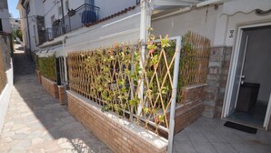 A narrow alley with a brick wall and a metal fence with climbing plants. - Residence a Palinuro ID 128 (Palinuro)