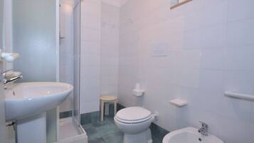 Ein Badezimmer mit Waschbecken, Toilette, Bidet und Duschkabine.