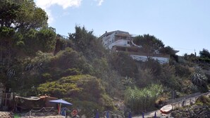 A beach with sun loungers, umbrellas, and a rocky shoreline. - Residence a Palinuro ID 127 (Palinuro)