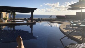 A pool area with a view of the ocean, lounge chairs, and a covered seating area. - X-Mas in CABO Novaspania- AMAZING - RESORT VILLA-  PRIVATE POOL- & QUIVIRA GOLF (Cabo San Lucas,)