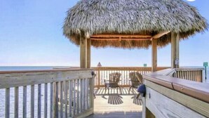 A wooden deck with a thatched roof structure, overlooking a body of water. - Key Largo-Islamorada area-1 BR, 1 Bath -Privately Owned Condo -Fab Reviews! (Tavernier)