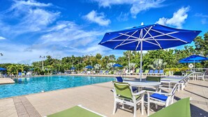 A poolside area with lounge chairs and umbrellas. - Key Largo-Islamorada area-1 BR, 1 Bath -Privately Owned Condo -Fab Reviews! (Tavernier)