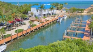 A waterfront property with a dock, boats, and a building with a blue roof. - Key Largo-Islamorada area-1 BR, 1 Bath -Privately Owned Condo -Fab Reviews! (Tavernier)