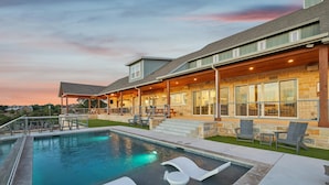 A modern outdoor pool area with lounge chairs and a covered patio. - PK LakeTime: 6 Bedroom/ 4 Bath Home with Dock, pool/hot tub, and game room (Strawn)