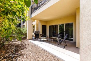 Une terrasse extérieure couverte, équipée d’un barbecue, d’un espace salon et offrant une vue sur l’intérieur du bâtiment.
