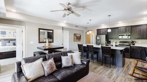 A modern kitchen with a bar area, a dining table, and a seating arrangement.