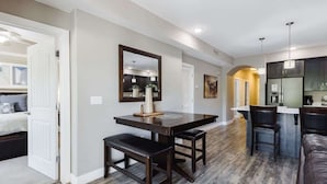 A modern kitchen with a dining area, a large mirror, and a bar.
