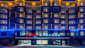 Ein mehrstöckiges Hotel mit moderner Fassade, beleuchteten Fenstern und einem gut sichtbaren Eingang.