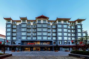 A multi-story hotel with a modern design, featuring balconies and large windows. - Hampton by Hilton Lijiang Old Town (Lijiang)