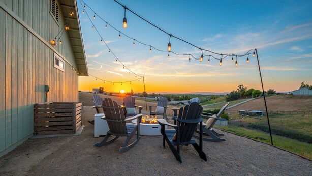 An outdoor seating area with chairs and a fire pit, overlooking a sunset. - The Sunset Ranchette : Luxury Paso Robles Getaway! (Paso Robles)