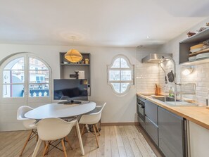 Una cocina moderna con comedor, ventanas amplias y televisión.