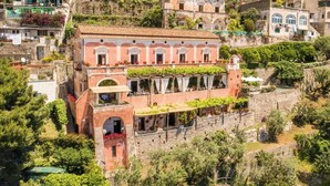 A historic building with multiple balconies, a stone facade, and a lush garden. - Villa San Giacomo - Unique Villa in Positano (Positano)