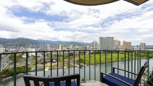 Un balcon offrant une vue sur le paysage urbain, une rivière et un parc.