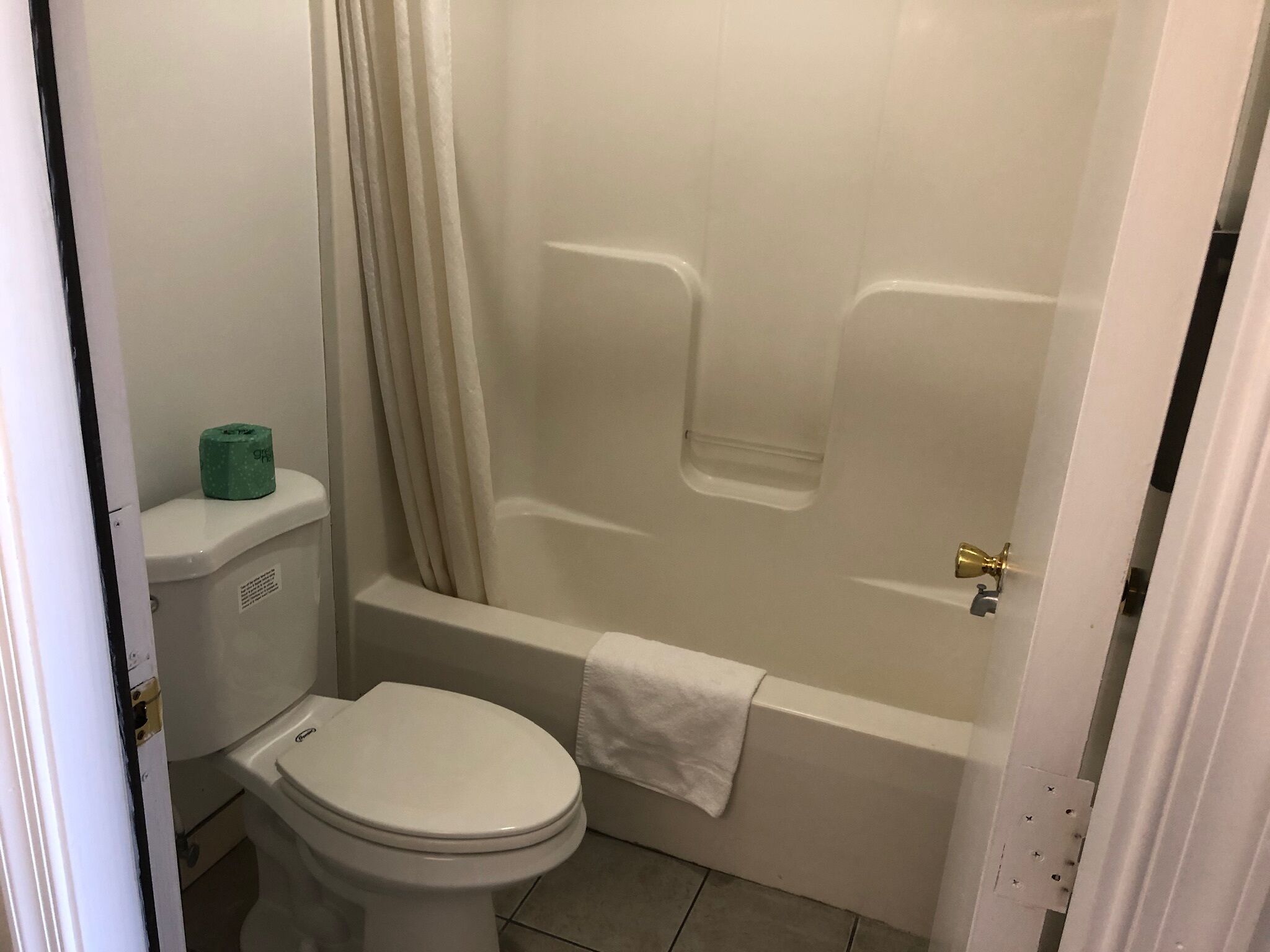 A bathroom with a toilet, a bathtub, and a shower curtain.