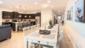 A modern kitchen with dark cabinets, a central island, and pendant lighting.