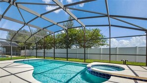 Una piscina exterior cubierta con un jacuzzi, rodeada por una estructura metálica y una valla blanca.