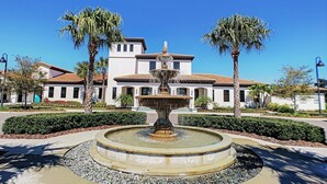 A building with a fountain in the center, surrounded by palm trees and well-maintained landscaping. - Lotus Garden by Florida Spirit (Kissimmee)
