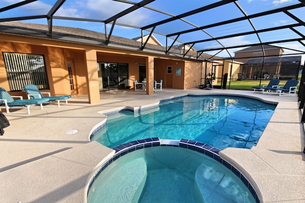 A swimming pool with lounge chairs and a covered patio area.
