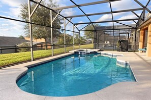 A swimming pool with a glass enclosure, surrounded by a patio area and a view of a residential neighborhood. - Florida Paradise by Florida Spirit (Davenport)