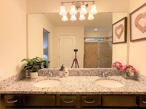A bathroom with two sinks, a mirror, and a potted plant.