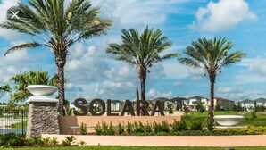 A sign for Solara Resort with palm trees and a clear sky. - Tropical Sunset by Florida Spirit (Kissimmee)