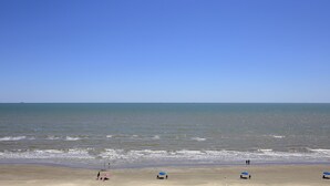 A beach with clear skies and calm waters. - Casa Del Mar Beach Suites (Galveston)
