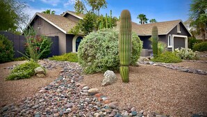 A residential area with a house, a large cactus, and a variety of desert plants. - 9 AM check in 9 PM check out, south facing sunny yard, Kierland area, 6 bikes (Scottsdale)