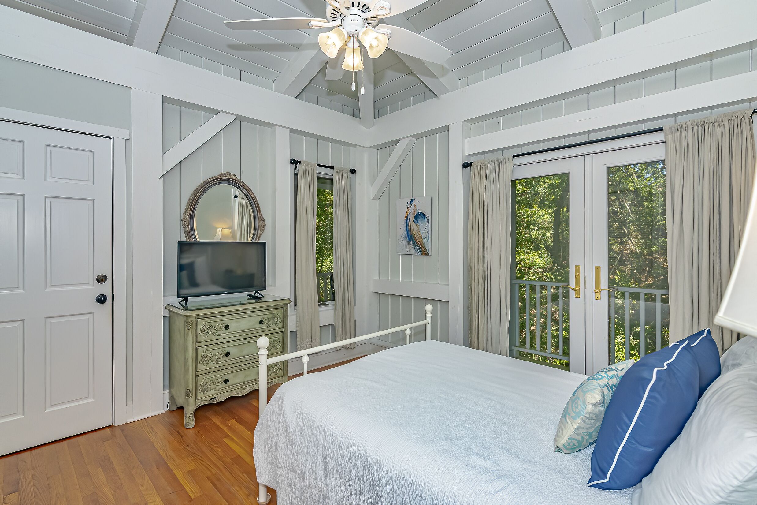 Un dormitorio con cama, cómoda y televisor.