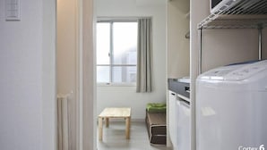 A laundry room with a washing machine, a drying rack, and a small wooden bench. - SHITAMACHI BASE/Quiet new apt.room101/skytree view (東京)