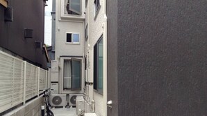 A narrow alleyway with a bicycle, air conditioning units, and a door leading to a building. - SHITAMACHI BASE/Quiet new apt.room101/skytree view (東京)