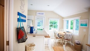 Una cocina acogedora con comedor, suelo de madera y ventanas amplias.