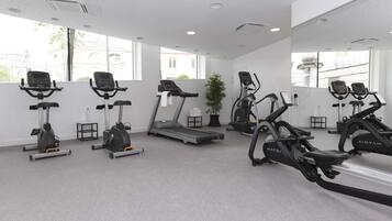 Ett gym med löpband, motionscyklar och ett löpband med en handduk.