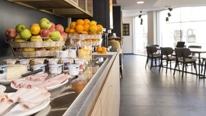 A buffet area with various food items including fruits, cheeses, and meats. - Studio Proche de la Sarthe, Accès Hammam (Le Mans)