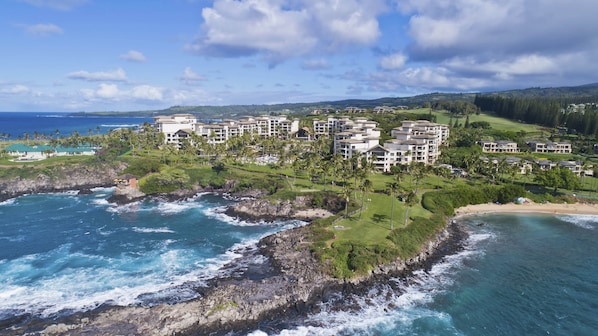 A coastal resort with multiple buildings, a rocky shoreline, and a view of the ocean.