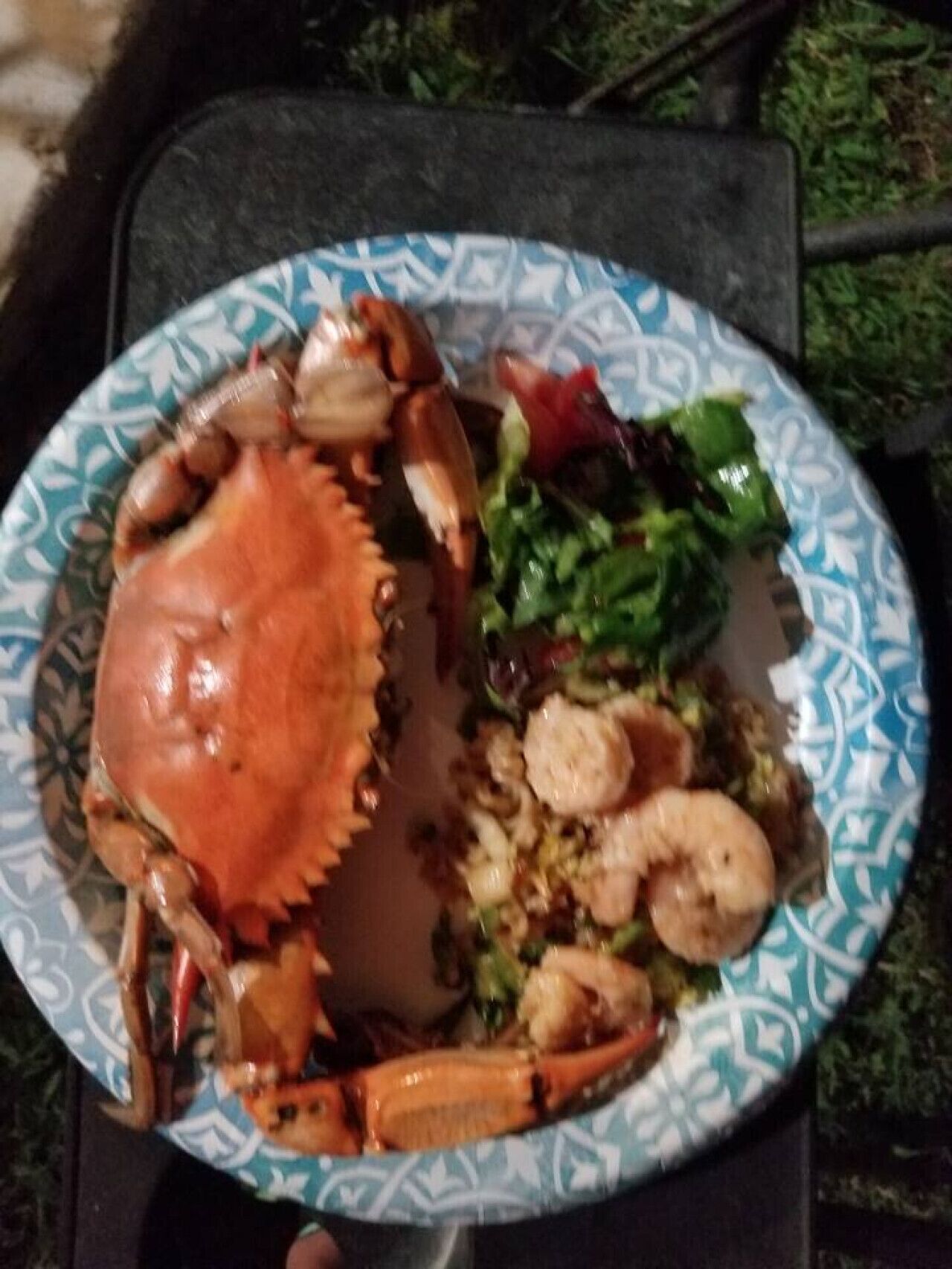 Une assiette contenant du crabe, des crevettes et une salade.