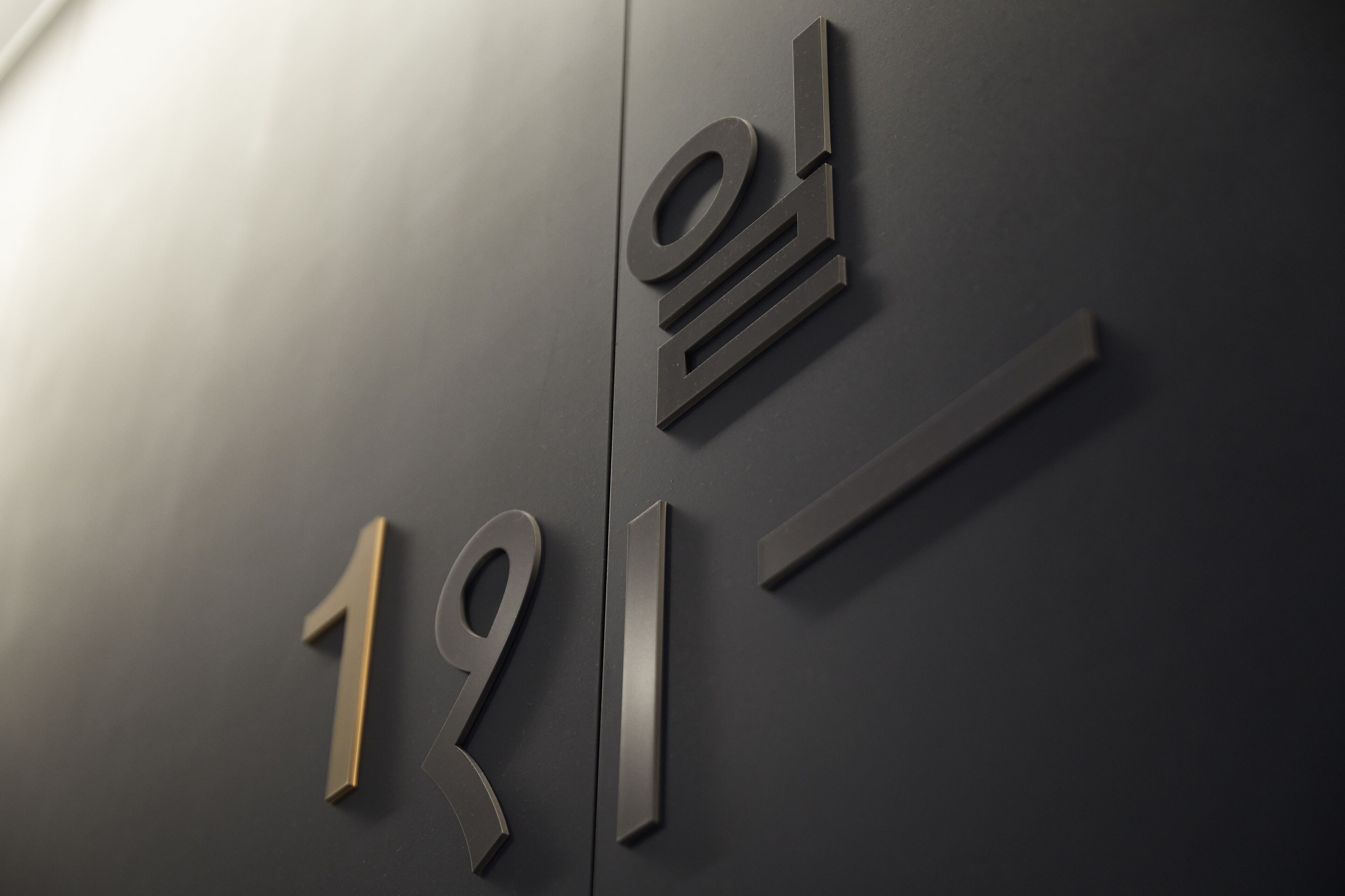 A modern building facade with large, metallic numbers and letters.