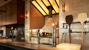 Una cocina moderna con horno de leña, electrodomésticos de acero inoxidable y un separador de vidrio.