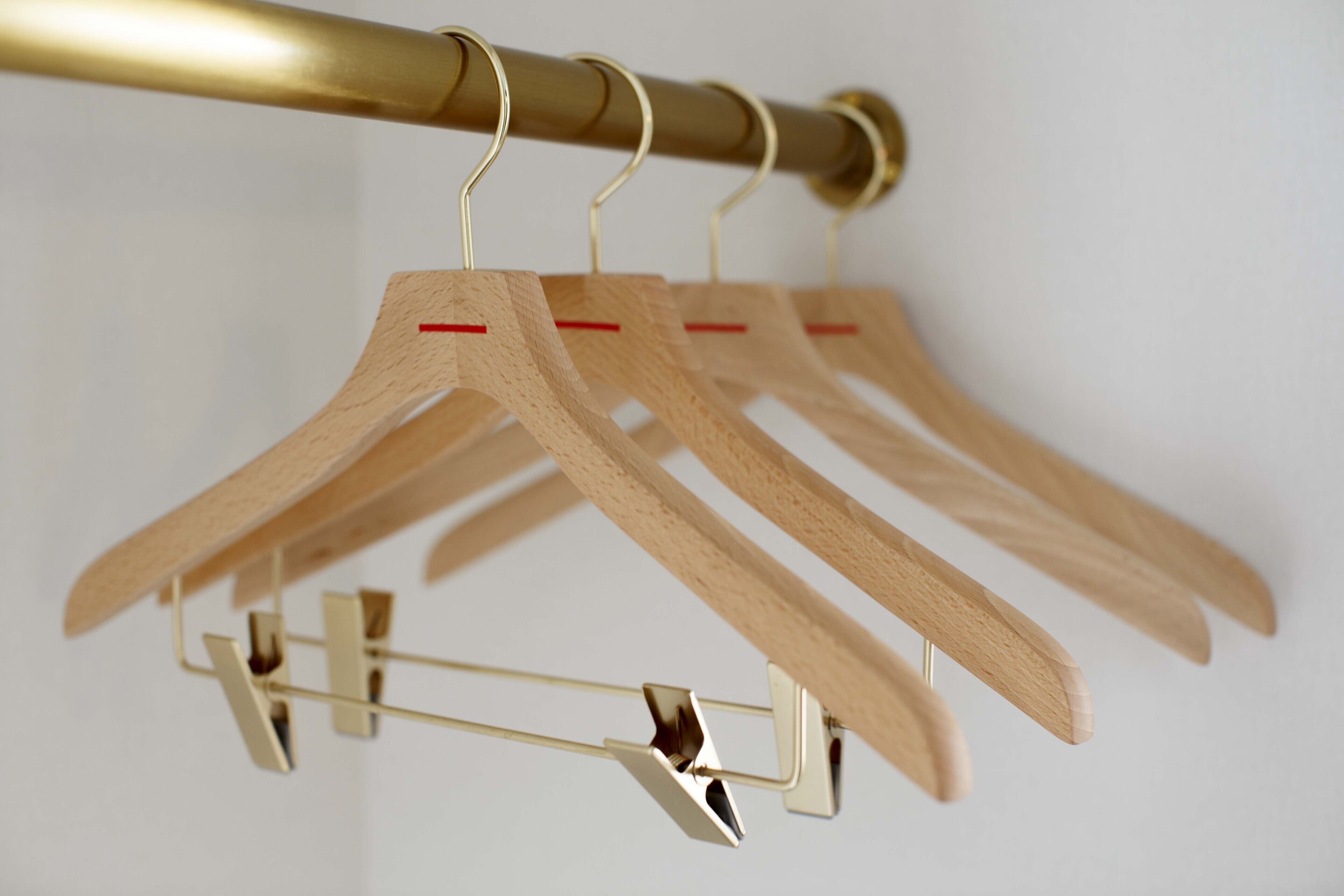 Perchas de madera colgadas en un perchero metálico.