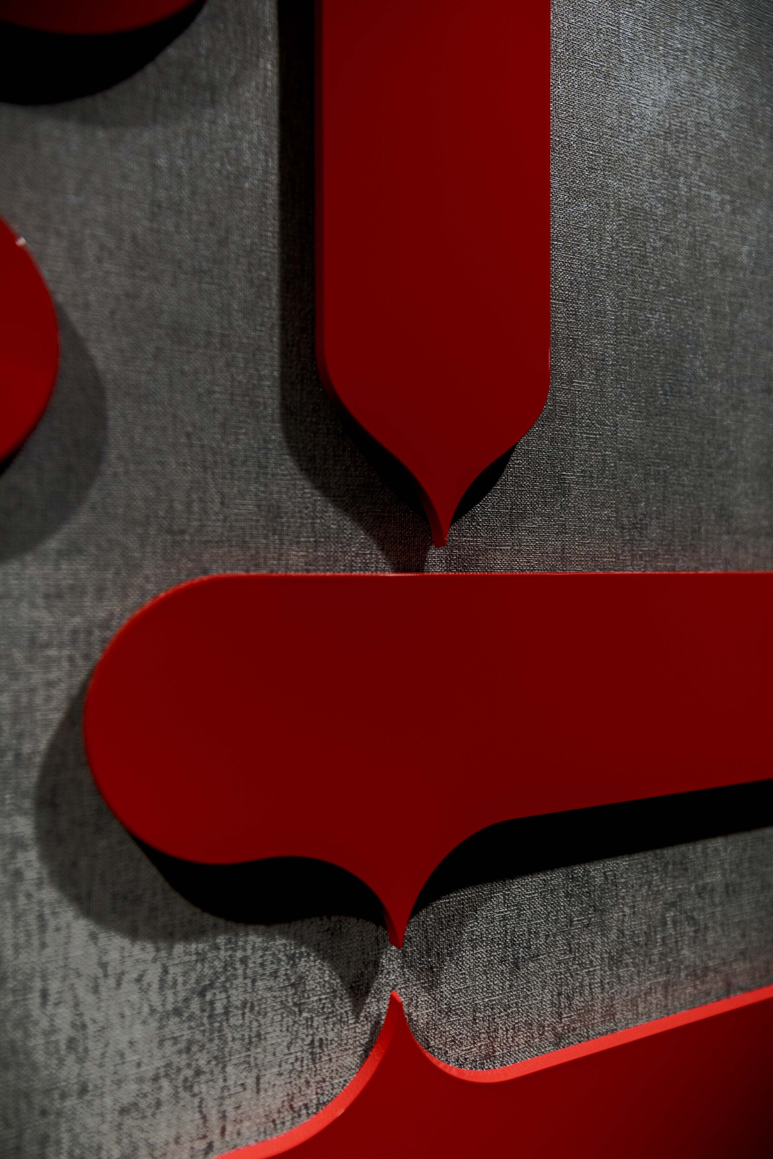 A close-up of a textured fabric with a red geometric pattern.