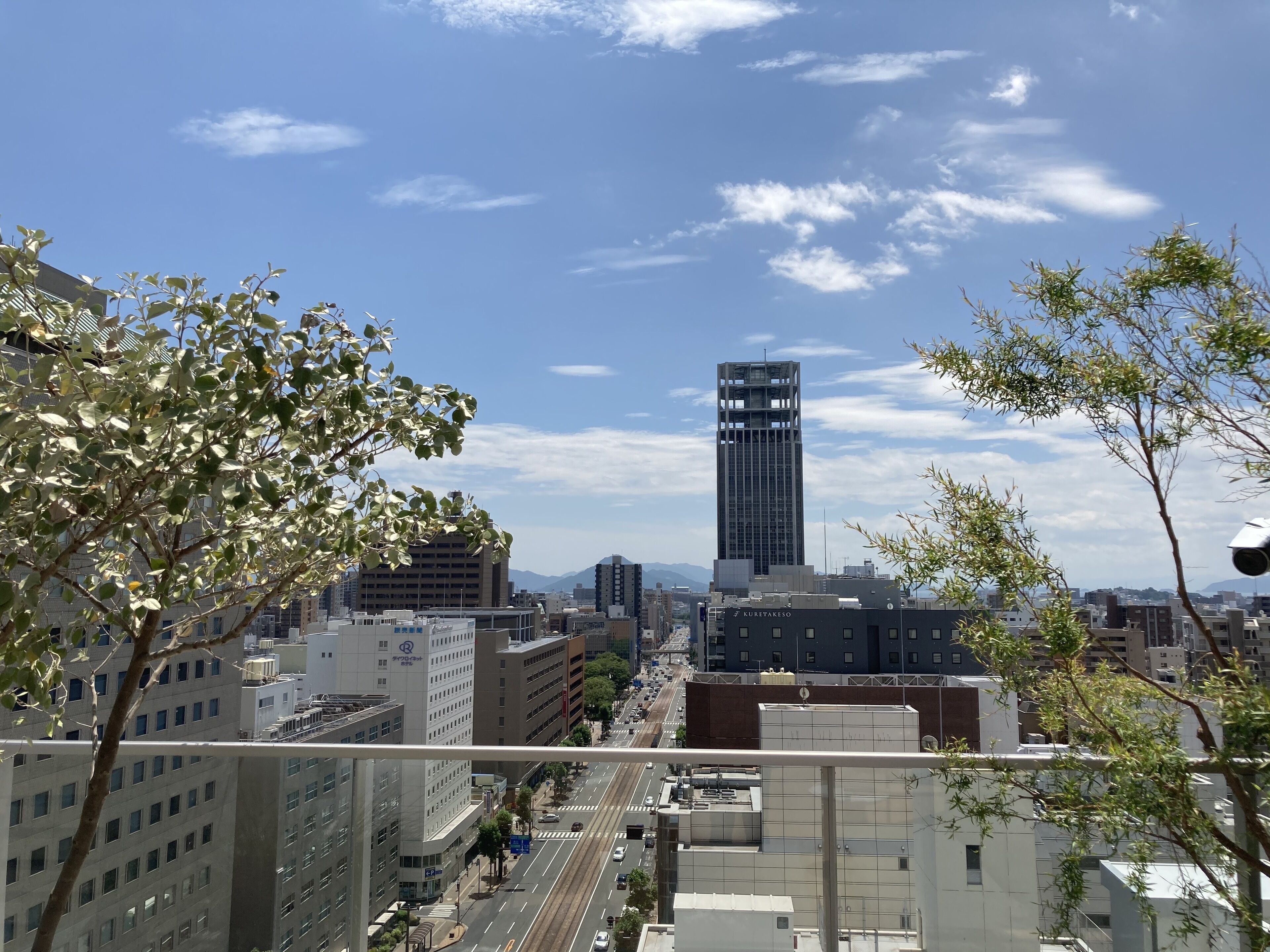 A cityscape with modern buildings, a prominent tower, and a clear sky.
