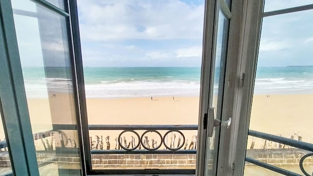 A view from a balcony overlooking a beach with a clear sky. - Les Armateurs by Interhome (Saint Malo)