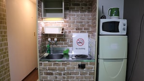 A compact kitchenette with a microwave, a small refrigerator, and a sink. - Guest House Zen Hakata (Fukuoka)