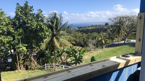 A wooden deck with a view of a lush garden and a distant landscape. - The Babanees - Bummer Hill Boho Chic Surf Shack  (Rincon)