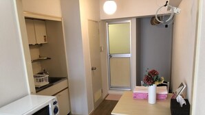 Eine kleine Küche mit einer Mikrowelle, einem Spülbecken und einem Tisch mit einem Blumenstrauß.