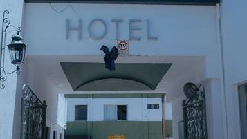 A hotel entrance with a sign reading "HOTEL" and a no parking sign.