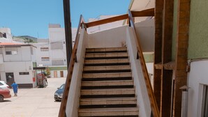 A staircase with a wooden handrail leading to an upper floor. - Hotel Zacatecas Courts (Zacatecas)