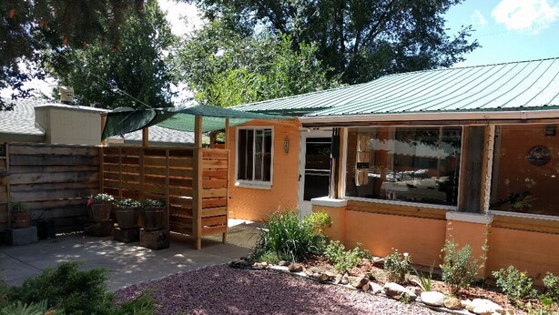 A small building with a metal roof, a wooden fence, and a gravel driveway. - Small studio in the quite neighbourhood. (Flagstaff)